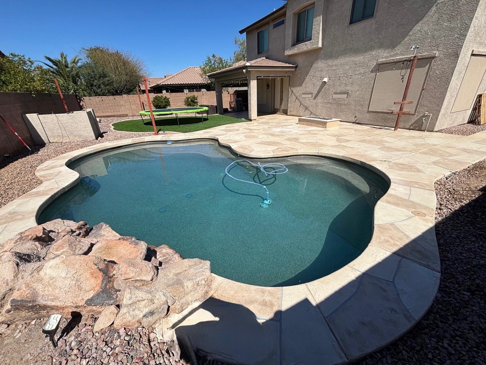 Completed flagstone-pattern pool deck resurfacing in Arizona backyard