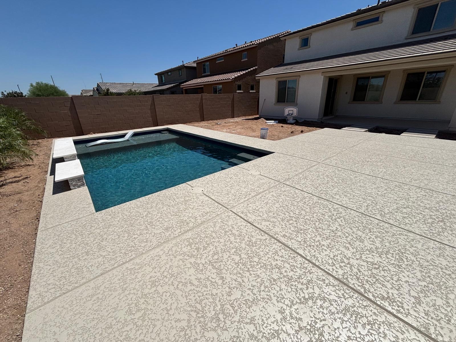 Finished cream textured cool deck coating around a Phoenix pool