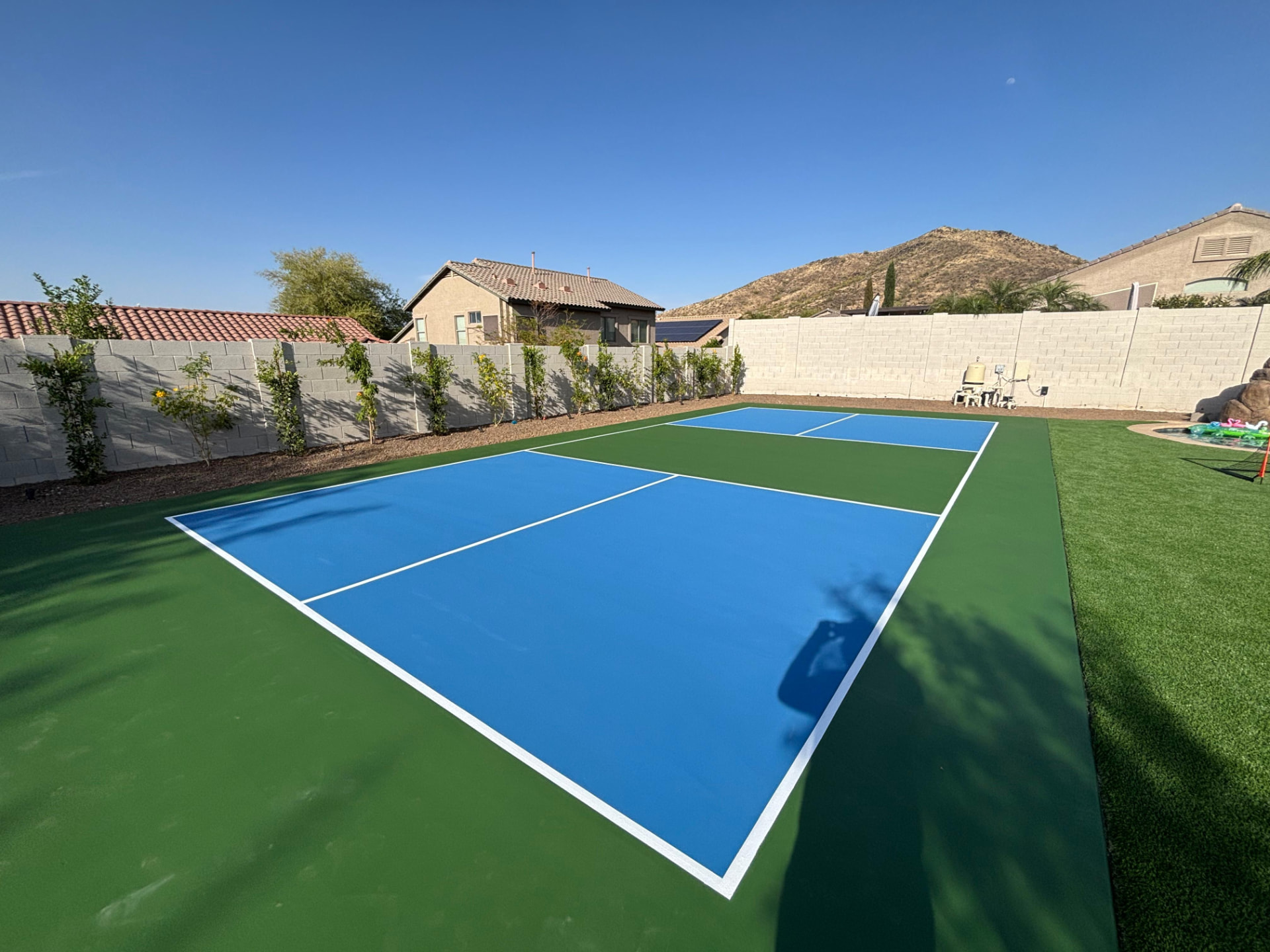 Blue and green regulation pickleball court installed in an Arizona backyard