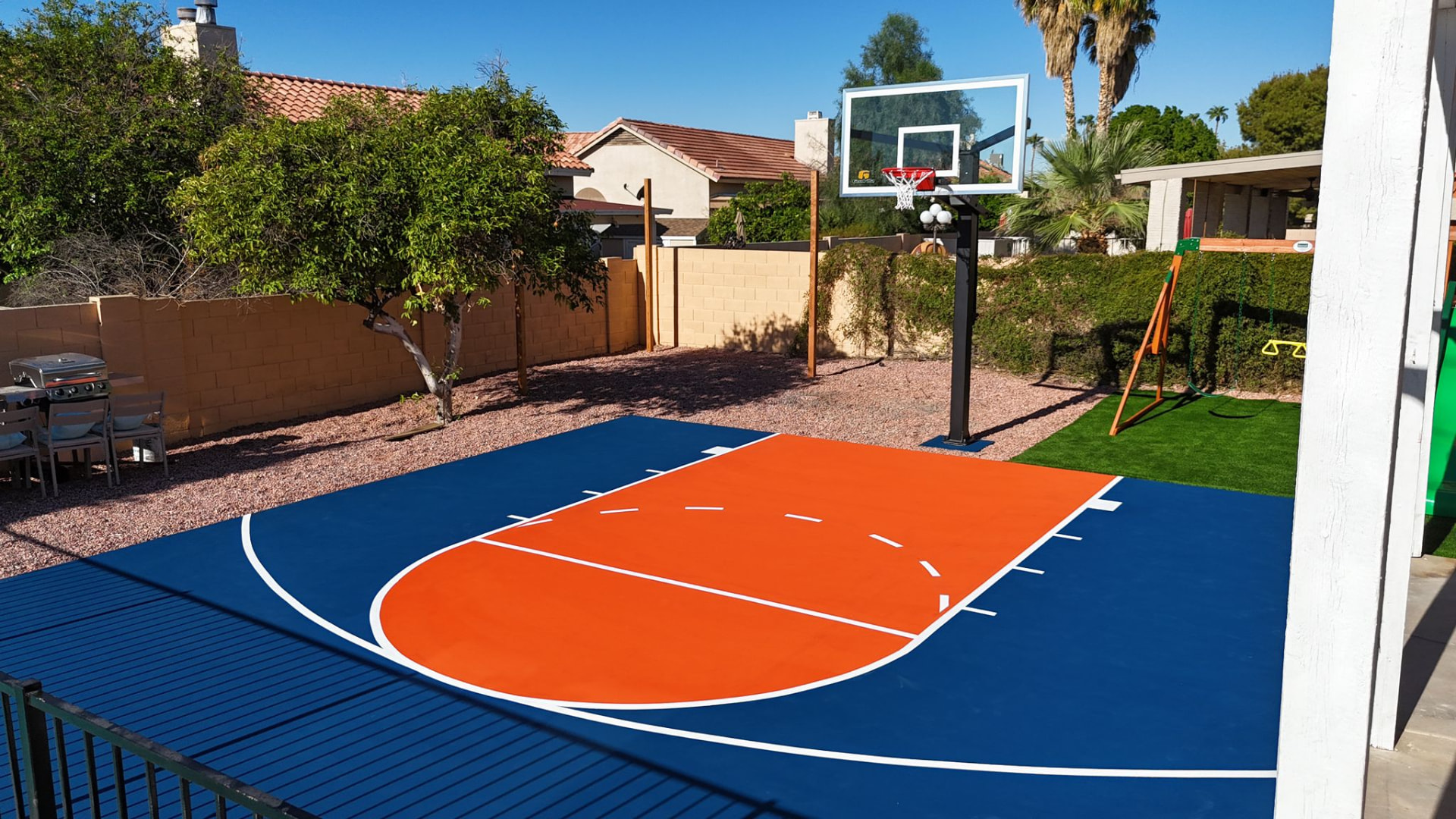 Navy and orange backyard basketball court with glass backboard